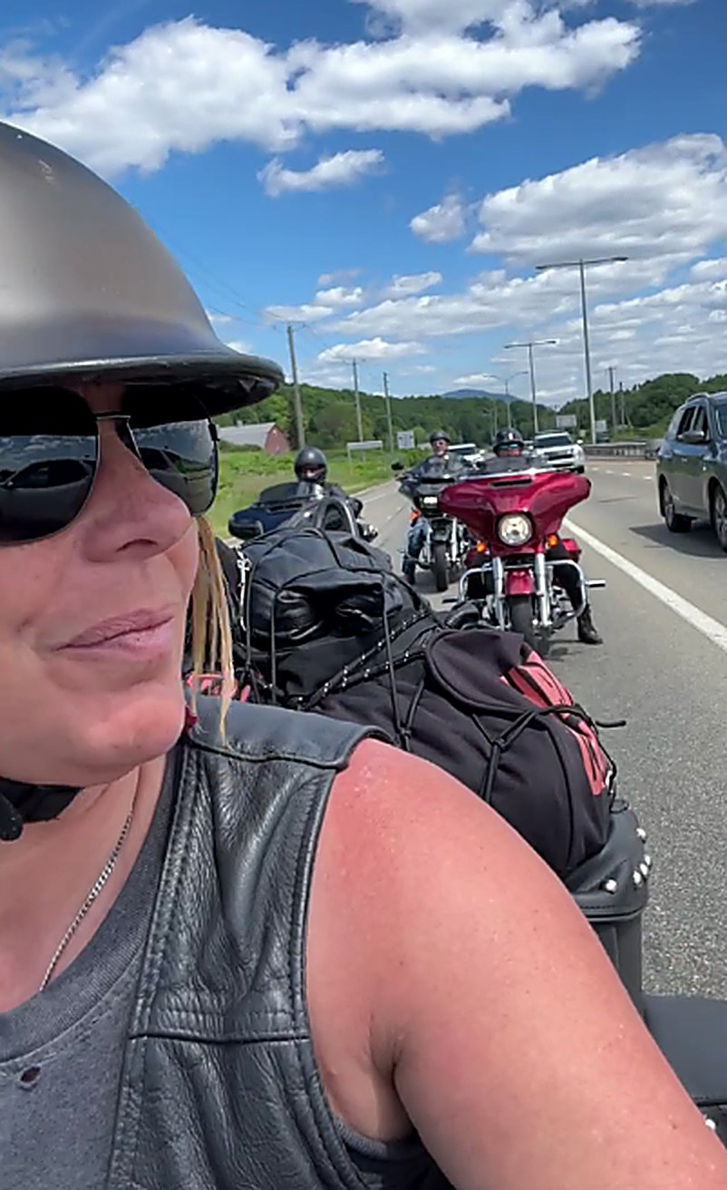 Une des filles du convoi, casque et lunettes, avec les motos de la Ride de Filles derrière elle